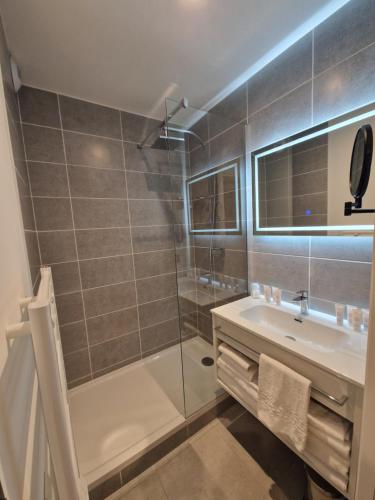 uma casa de banho com um chuveiro, uma banheira e um lavatório. em Appart'hôtel Marianne em Montpellier