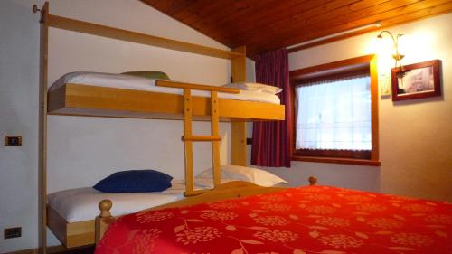a bedroom with two bunk beds and a bed at campiglio; dedica a te la calda mansarda di pia in Madonna di Campiglio
