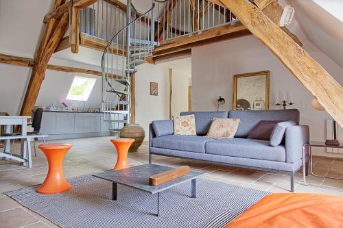 un salon avec un canapé bleu et une table dans l'établissement Domaine La Restrie - Le Voyage d'Erasme, à Pocé-sur-Cisse