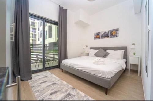 a bedroom with a bed and a large window at Studio Converted to 1BDR in The Nook Close to Metro in Dubai