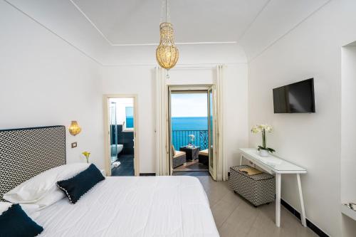 a bedroom with a bed and a desk and a television at Villa Gianlica in Praiano