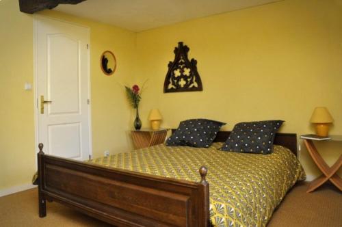 a bedroom with a bed with blue pillows on it at La Grande Combe in Saint-Izaire