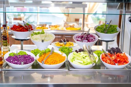 a buffet filled with bowls of vegetables on a counter at MPM Hotel Arsena - Ultra All Inclusive in Nesebar