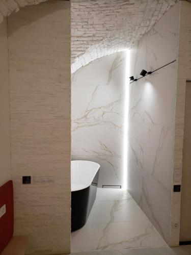 a bathroom with a white marble wall at Red & Yellow Old Town in Lviv