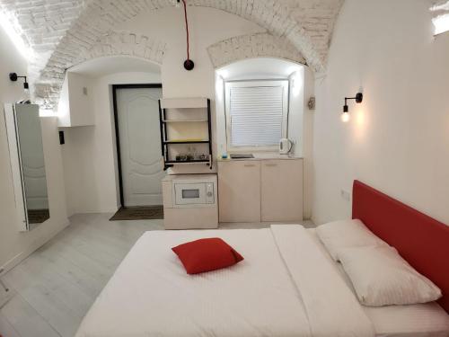 a white room with a bed with a red pillow on it at Red & Yellow Old Town in Lviv