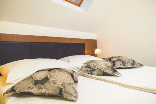two beds with pillows on them in a bedroom at Etno selo Stanišići Hotel Leonida in Dijelovi