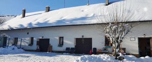 a white house with a snow covered roof at TUTTO House&Home in Lubno