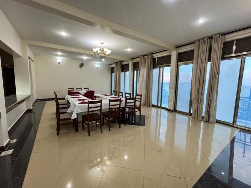 comedor con mesa, sillas y ventanas en Victoria Rock Resort, en Entebbe