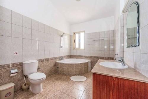 ein Badezimmer mit einem WC, einer Badewanne und einem Waschbecken in der Unterkunft Villa Theo in Peyia