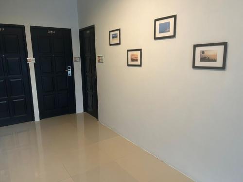 a room with black doors and pictures on the wall at Hotel The Journey Patong New in Patong Beach