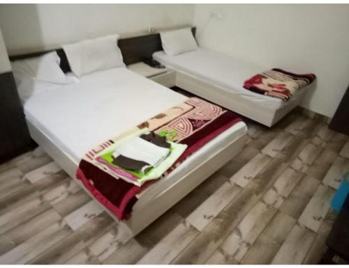 dos camas sentadas una al lado de la otra en una habitación en HOTEL MADHUVAN, Madhavpur, en Mādhavpur
