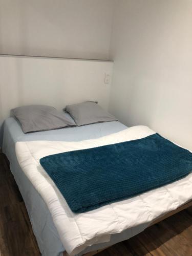 ein Bett mit einer blauen Decke darüber in der Unterkunft Appartement Mende 2 Chambres Canapé lit WIFI Gratuit in Mende