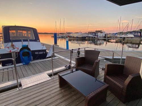 a deck with two chairs and a table on a boat at Ferienzentrum Yachthafen Rechlin in Rechlin