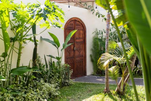 een houten deur in een huis met planten bij Karma House Ungasan in Jimbaran