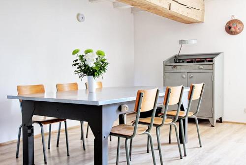 - une table à manger avec des chaises et un vase fleuri dans l'établissement Domaine La Restrie - La Bulle de Michel-Ange, à Pocé-sur-Cisse
