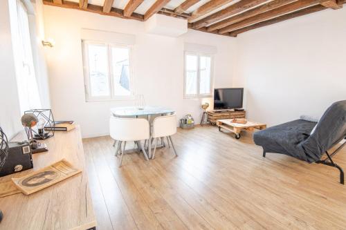 ein Wohnzimmer mit einem Tisch und einem Sofa in der Unterkunft Le boudoir d'adelaïs in Amboise
