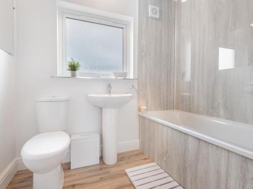 a bathroom with a toilet and a sink and a tub at 4 Bed in Penrith SZ606 in Plumpton Wall