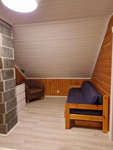 a room with a bed and a chair in a attic at Levi Piippo 2 in Kittilä