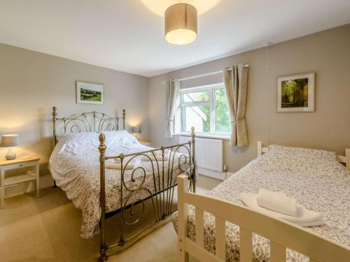 a bedroom with two beds and a window at 8 Bed in Clovelly 85428 in Woolfardisworthy