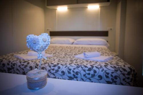 1 dormitorio con 1 cama con colcha azul y blanca en Camping Sestola, en Sestola
