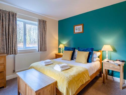 a bedroom with a large bed with blue walls at 3 Bed in Ullswater 85896 in Penruddock