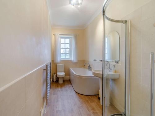 a bathroom with a tub and a sink and a shower at 4 Bed in Buttermere 85979 in Buttermere