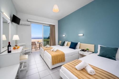 a hotel room with two beds and a view of the ocean at Bayside Hotel Katsaras in Kremasti
