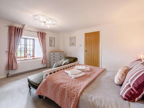a bedroom with a large bed and a chair at 4 Bed in Bude 85839 in Morwenstow