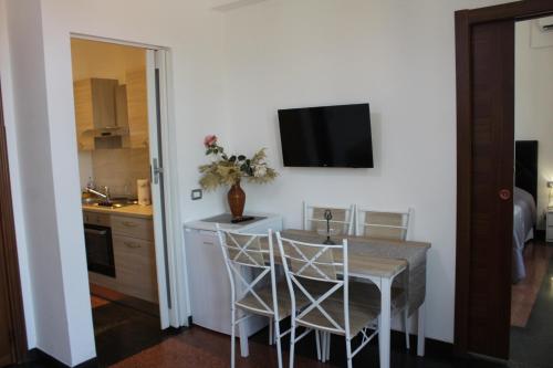 a kitchen with a table with chairs and a tv on the wall at LA LANTERNA DI ANGELO rent rooms and apartments free parking on the street front in Genova