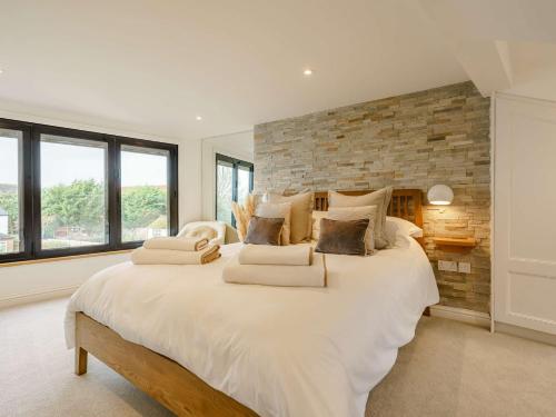 a bedroom with a large white bed with a brick wall at 3 Bed House With Hot Tub Great Ayton - TOP Terrace in Great Ayton