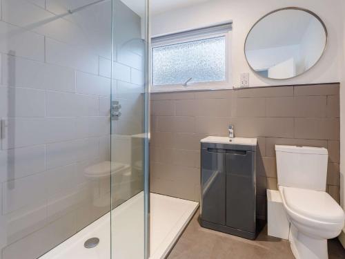 a bathroom with a shower and a toilet and a mirror at 3 Bed in Widemouth Bay 86151 in Marhamchurch