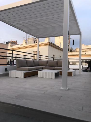 a couch sitting under a pavilion on a roof at Apartamentos GADIR CENTRO in Cádiz