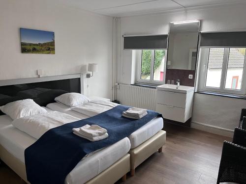 a bedroom with a large bed and a sink at Gasterij Berg en Dal in Slenaken