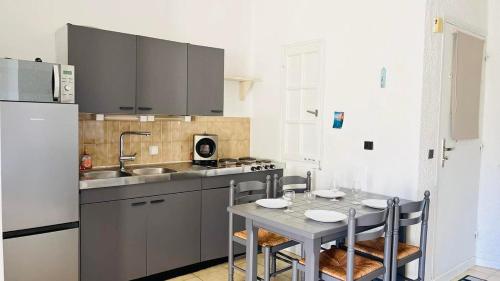 La cuisine est équipée d'une table, d'un évier et d'un réfrigérateur. dans l'établissement Studio PORTO 39 Lumio, à Lumio