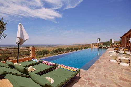 a pool with chaise lounge chairs and a swimming pool at Dar Imiri in Ourika
