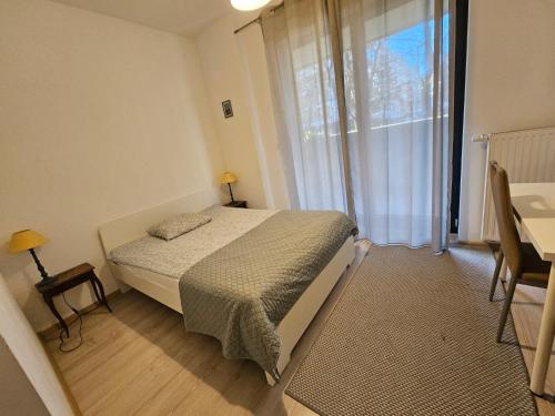 a bedroom with a bed and a large window at FIRST - Green Żoliborz Apartment 6 in Warsaw