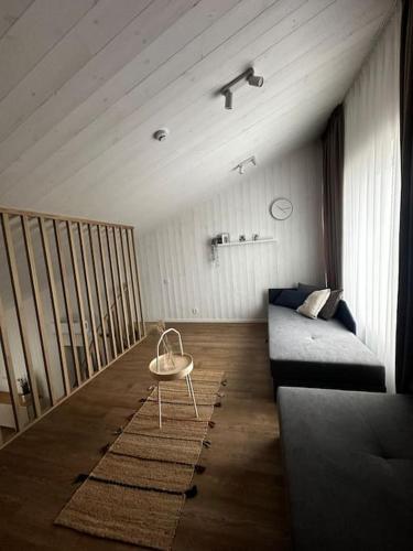 a living room with a couch and a table at Jaukūs apartamentai Svencelėje in Svenele
