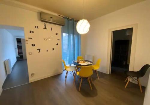 une pièce avec une table et une horloge au mur dans l'établissement Eden Garden climatisé avec une terrasse, à Montargis