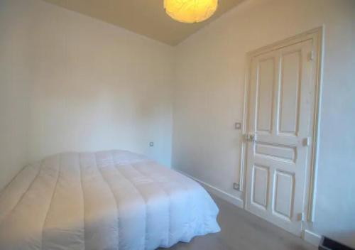 - une chambre avec un lit blanc et une porte dans l'établissement Eden Garden climatisé avec une terrasse, à Montargis