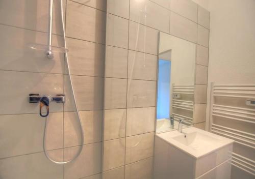 une salle de bain avec douche et lavabo dans l'établissement Eden Garden climatisé avec une terrasse, à Montargis