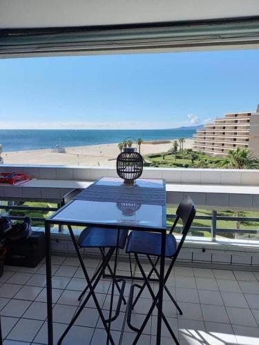 d'une table et d'une chaise sur un balcon avec vue sur la plage. dans l'établissement Refait à neuf avec grande terrasse vue mer, à Canet