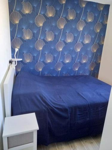 - une chambre avec un lit bleu et un mur bleu dans l'établissement Refait à neuf avec grande terrasse vue mer, à Canet