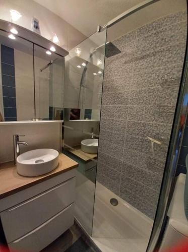 La salle de bains est pourvue d'une douche en verre et d'un lavabo. dans l'établissement Refait à neuf avec grande terrasse vue mer, à Canet