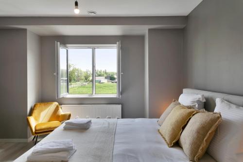a bedroom with a large bed and a yellow chair at Het Zwinhuis - Spacious and comfortable family home near 't Zwin in Knokke-Heist