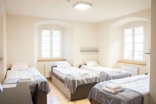 three beds in a room with three windows at Dom "Na Szlaku Cysterskim" in Krzeszów