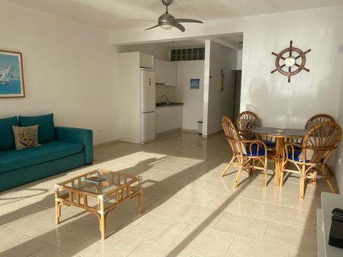 ein Wohnzimmer mit einem Sofa, einem Tisch und Stühlen in der Unterkunft Aparthotel Praia Baixo in São Tiago