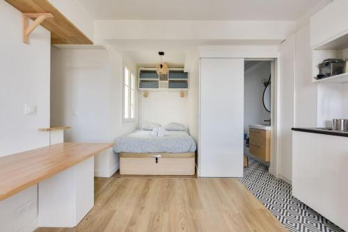 - une chambre avec un lit au milieu d'une pièce dans l'établissement Splendide studio au cœur du 15e arr, à Paris