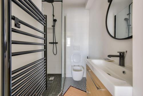 La salle de bains est pourvue de toilettes, d'un lavabo et d'un miroir. dans l'établissement Splendide studio au cœur du 15e arr, à Paris