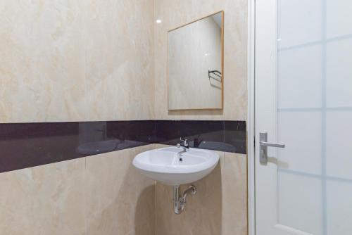 een badkamer met een wastafel en een spiegel bij RedDoorz Plus @ La Asiana Guest House in Kanggraksan