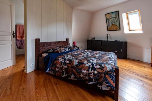 1 dormitorio con 1 cama y suelo de madera en Le Pradima en Mandailles